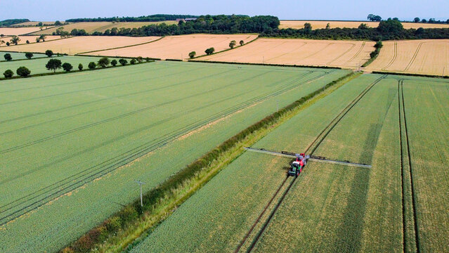 Agriculture - Aerial view of a farm vehicle spraying farmland in North Yorkshire in the United Kingdom.