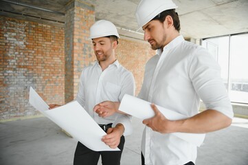 Two young man architect on a building construction site