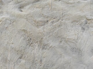 Abstract paint is peeling off the building wall.Close-up. Badly fixed building facade wall covered with cracks in stucco and paint. Missing patch of paint in the middle; crack with flappy.