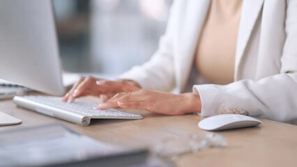 Closeup of a receptionist typing and sending emails while working in an office alone. One secretary doing admin and writing reports while organizing a schedule for her manager at work