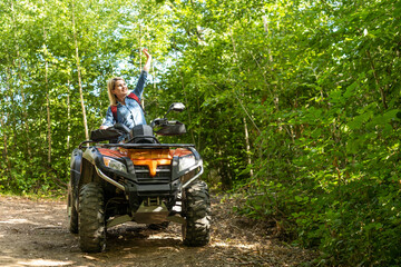 Young happy woman enjoying extreme ride on atv quad motorbike in autumn mountains at sunset