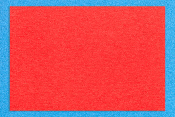 Texture of craft bright red color paper background with blue border, macro. Structure of vintage dense kraft cardboard