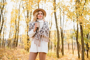 Happy smiling young woman in park on autumn day.