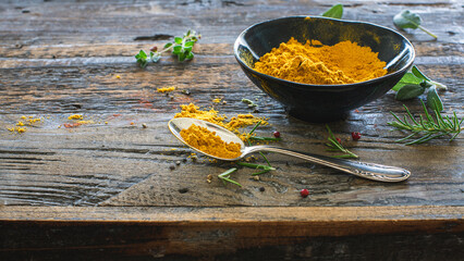 Curry in einer Schale und auf einem Löffel garniert mit firschen Kräutern und Pfeffer -...