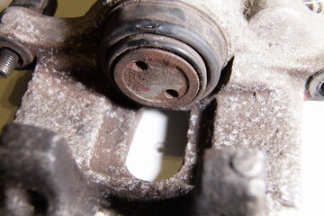 Old single piston hydraulic brake caliper with broken brake piston cup close up, car brakes repair - obrazy, fototapety, plakaty