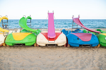 Pedal boats in the beach. Colorful plastic pedal boats to rent.