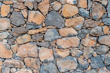 Textura de pared de piedra volcánica natural antigua, con diferentes colores