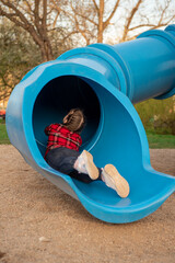 The girl rolls down the hill. Sliding down. Large children's slide-tube. children's playground....