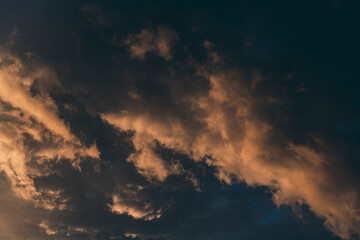 Beautiful evening sky with multi-colored bright clouds. Rain clouds at sunset. High-quality photo