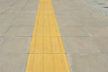 Braille block yellow installed on concrete footpath.	