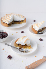 Sand cake with cherries. White background with dessert. Baking with meringue. The pie is cut.