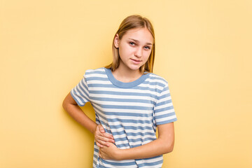 Young caucasian girl isolated on yellow background having a liver pain, stomach ache.