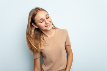 Obraz premium Young caucasian girl isolated on blue background dancing and having fun.