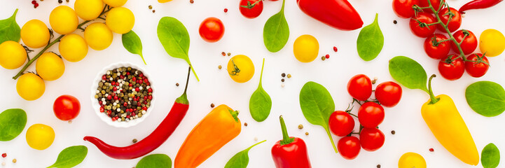 Yellow and red tomatoes, hot peppers, spinach and spices on a white background, food banner, top view