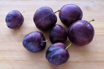 Sweet ripe plums on a wooden rustic table.