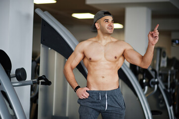 Fit and muscular arabian man posing in gym.