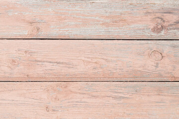 Fototapeta na wymiar Peeling paint on a wooden floor. Soft pink abstract background of horizontal boards, grunge cracked painted surface, pattern texture. Weathered old wood table. Rustic design. Template with blank space