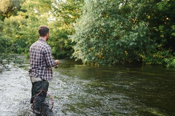 Young man flyfishing at sunrise