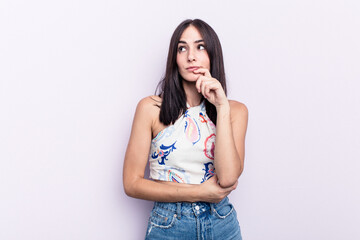 Young caucasian woman isolated on pink background thinking and looking up, being reflective, contemplating, having a fantasy.