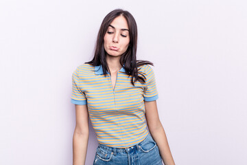 Young caucasian woman isolated on pink background shrugs shoulders and open eyes confused.