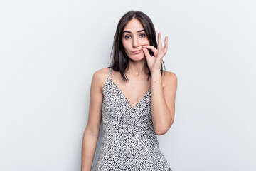 Young caucasian woman isolated on white background with fingers on lips keeping a secret.