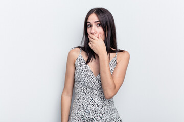 Young caucasian woman isolated on white background covering mouth with hands looking worried.