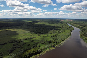Floodplain of the Pina river with a meadow in a wild landscape and a blue sky with clouds.
