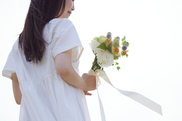 ドレスを着て花束を持つ若い日本人女性