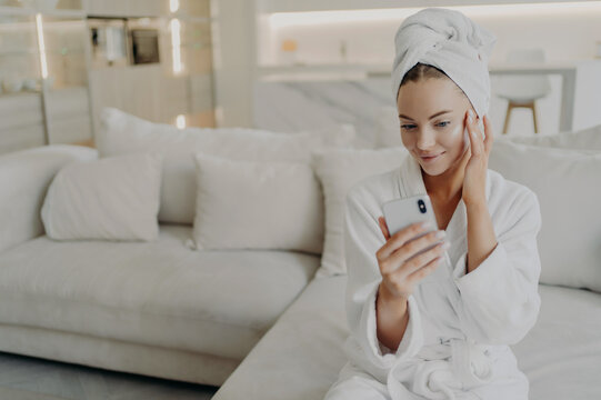 Woman beauty blogger creating video on smartphone for her vlog about daily skincare routine