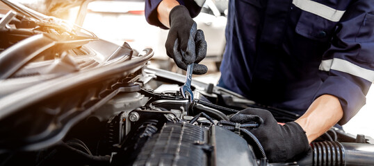 Car care maintenance and servicing, Close-up hand technician auto mechanic using the wrench to...