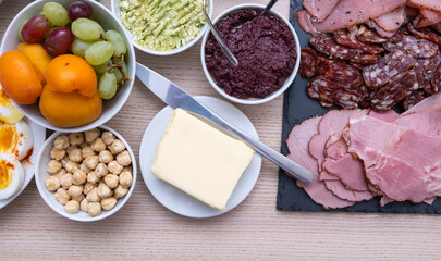 Top down view different meats, vegetables, nuts, and fruits on a table