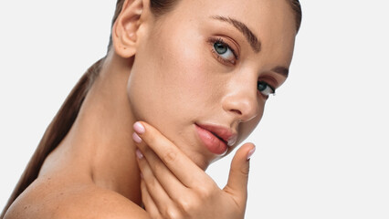 portrait of pretty young woman with clean skin touching face isolated on white.