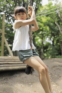 ターザンロープで遊ぶ女子小学生 (7歳)