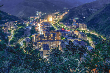 Night city from a bird's eye view. The light of houses and cars. A beautiful city with rivers, bridges and beautiful buildings. City among the mountains, Kapan, Armenia