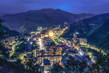 Night city from a bird's eye view. The light of houses and cars. A beautiful city with rivers, bridges and beautiful buildings. City among the mountains, Kapan, Armenia