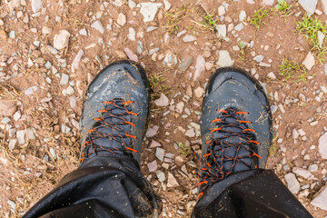 Foam from the water coming out of wet approach shoes on the legs of the tourist after intensive trekking on the trail after the rain. - 519142947