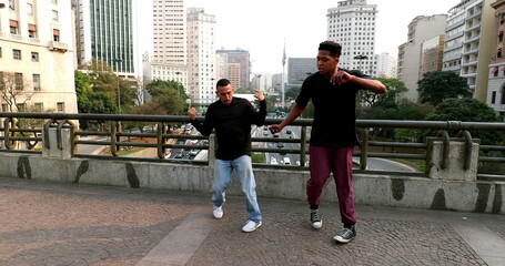 Obraz premium Happy hispanic and black African man dancing in city