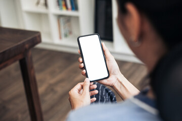 cell phone blank white screen mockup.hand holding texting using mobile on desk at office.background...