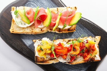 Tasty bruschetta with fish and baked peppers
