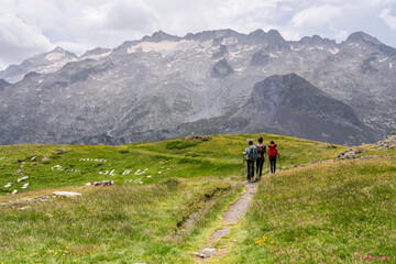 Fototapeta na wymiar walking in front of the Maladeta massif, route to France through the Portillon pass, Benasque Valley, Huesca, Pyrenean mountain range, Spain