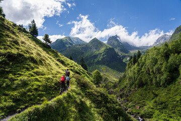 Fototapeta na wymiar hikers on the trail, Ascending towards Hourgade Peak, L´Ourtiga, Luchon, Pyrenean mountain range, France