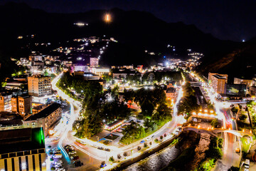 Night city from a bird's eye view. The light of houses and cars. A beautiful city with rivers, bridges and beautiful buildings. City among the mountains, Kapan, Armenia