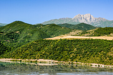 Beautiful mountain, green forests and yellow fields. Blue sky and beautiful mountain