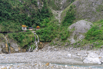 Beautiful scenic of the shrine on the cilff with waterfall down to the river.