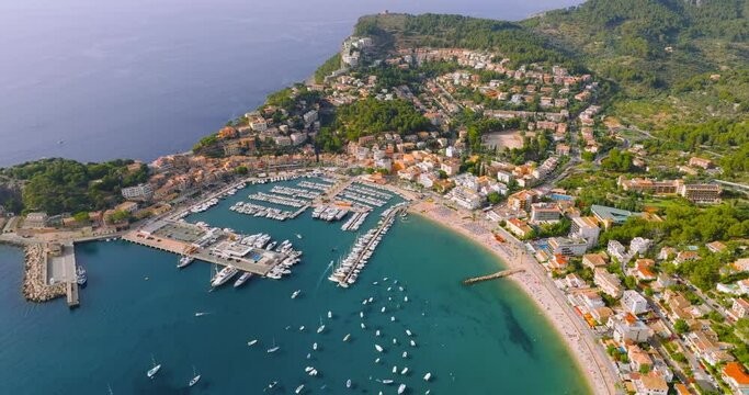 Aerial view of summer resort town Port de Soller on Majorca island, sandy beach, boats, yachts, clear waters of Mediterranean Sea - landscape of Balearic Islands from above, Europe.
