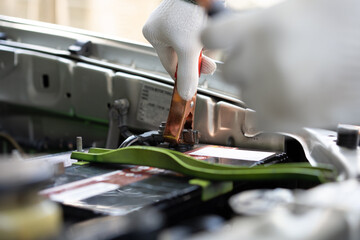Close up and Selective focus of car mechanic holding battery electricity cables jumper for charging car battery, Services car engine machine concept