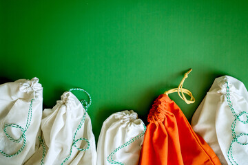zero waste products in reusable cotton bags on a green background