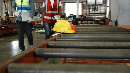 Two people wear safety uniform and helmet to work in industry factory handle document folder and checklist. Two people engineer worker together in factory workshop industry concept professional.