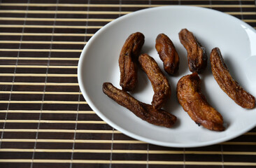 Dried sweet bananas white on white background. Green natural background. White isolated background. Vegetarian food.