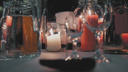 Wine Glasses Water Jug and Decorative Wax Candle Prepared for Romantic Wedding Reception Evening Dinner	
